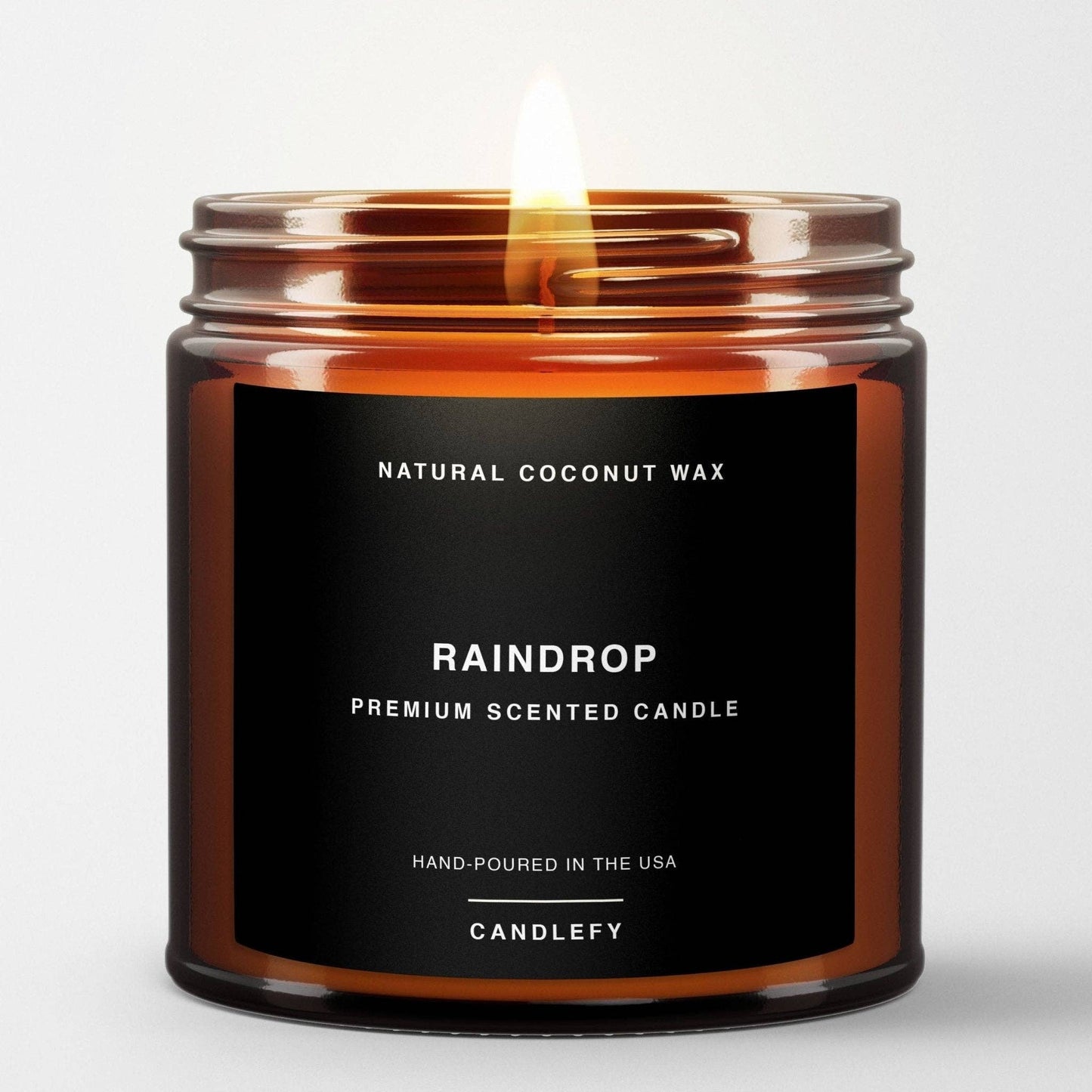 Raindrop Premium Scented Candle in amber glass jar with white floral scent of lily and rose petals