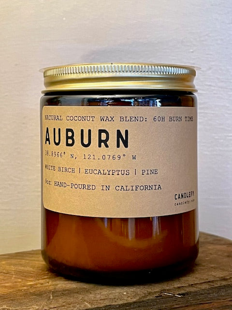Auburn scented candle with birch, eucalyptus, and pine in a brown jar with gold lid